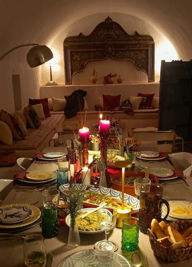 Une table colorée et des plats à partager dans une pièce aux lumières chaudes