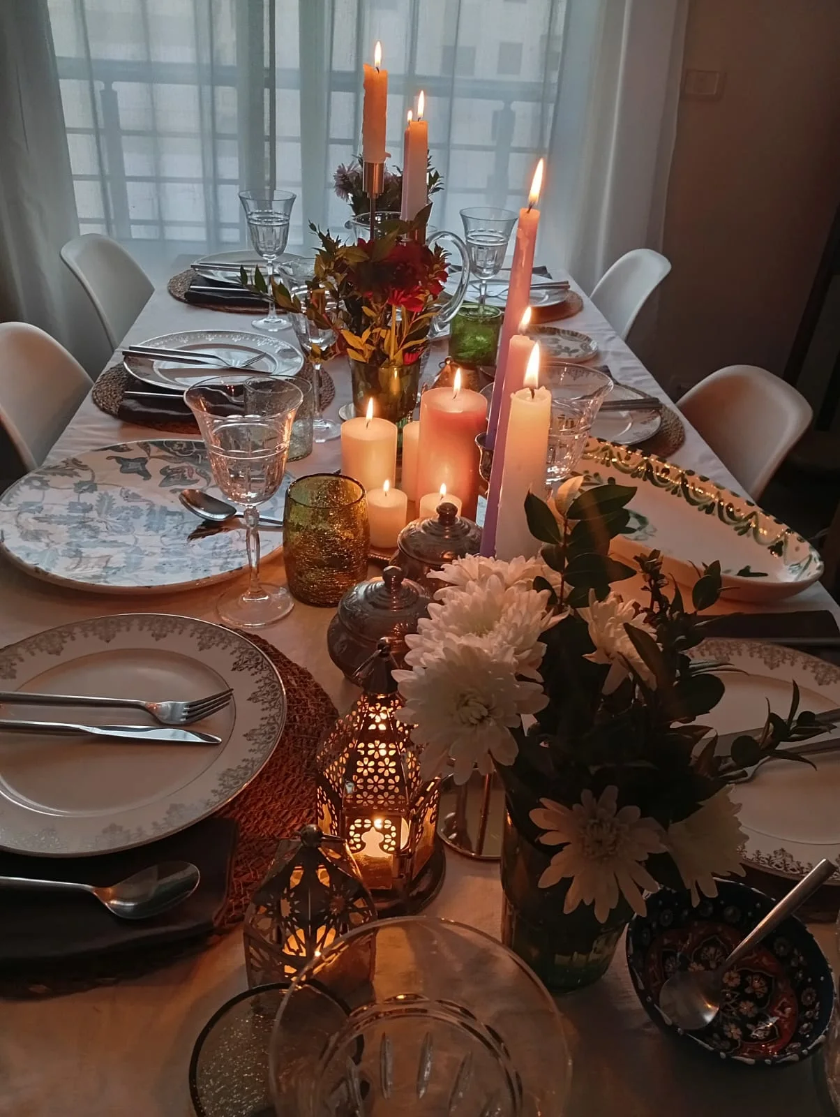 Une table dressée de fleurs, de vaisselle et de bougies dans la maison de l’artiste