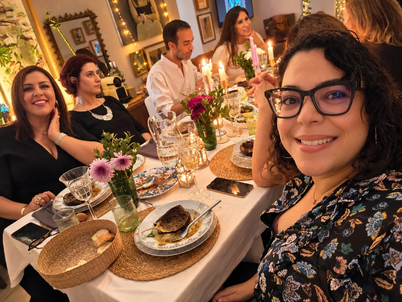 Des convives réunis autour de la table, entre fleurs, bougies et conversation